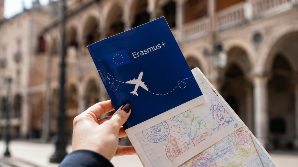 Erasmus booklet and travel map held in front of a historic Padova university building